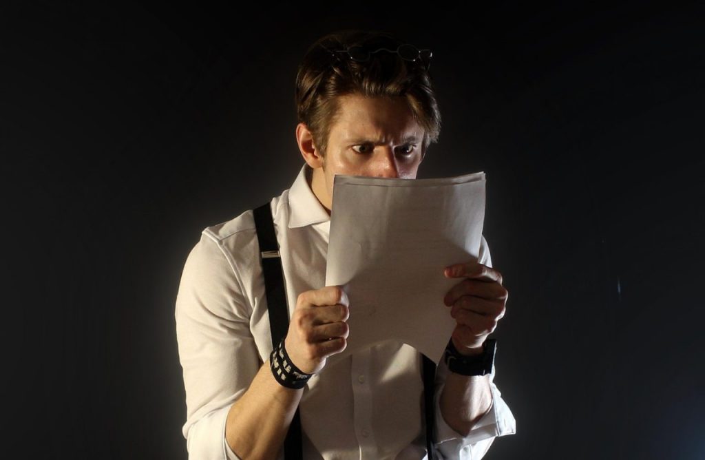 uomo che legge un documento su sfondo nero