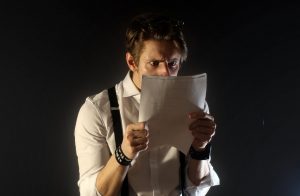 uomo che legge un documento su sfondo nero